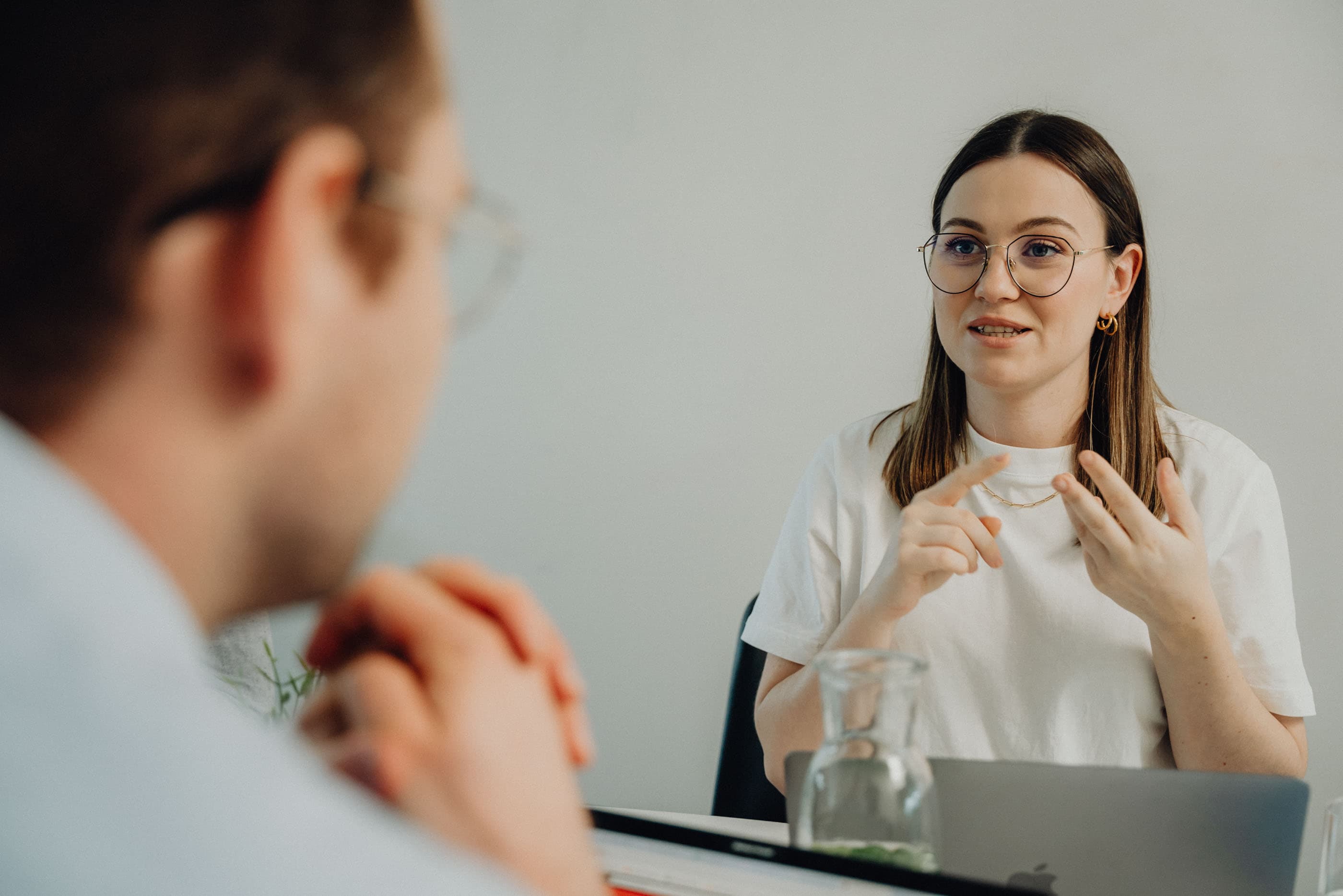 Two people discussing software development at a laptop in a modern office.